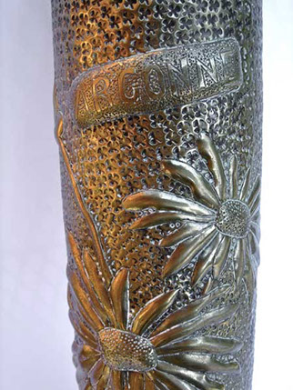 Shell with banner Argonne embossed with two large daisy on abackground of spoked punches.