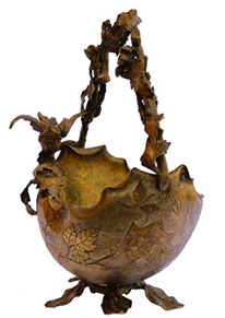 A metal basket with handle of branches, a bird on the rim. Leaves as pedestal. When upside down, this basket has the shape of a helmet