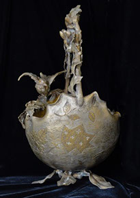 Metal basket with scalloped rim, bird perched on the rim. Outside decoration of silver and gold tones leaves and&nbsp; speckled patterns.