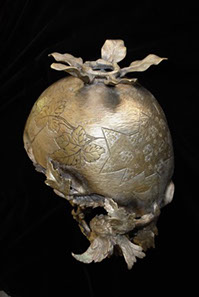 Upside down metal basket shows a helmet shape with scalloped rim and botanical decoration.