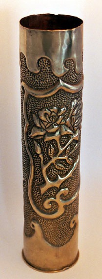 Shell with medallion filled with roses. Top and bottom have a wavy pattern. Back embossed.