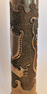 Shell with shield from the Middle-Ages with edges of dots, banner below.