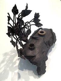 5kg of debris from ordnance transformend n an inkstand with a pen holder snake, foliage vertical as background. M.CIMONE 1917