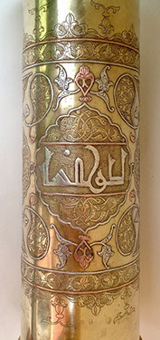 Shell heavily decorated with Damascene work of inlaid copper and silver and Arabiam calligraphy in central medallion.