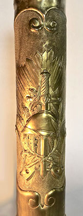 Shell with a vertical French short sword resting on an Adrian helmet. Oak and olives branches and sunburst symbol of renewal.