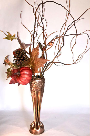 Shell with eight long flutes and a bulbous top embossed with daisies. Bouquet of fall dry flowers.