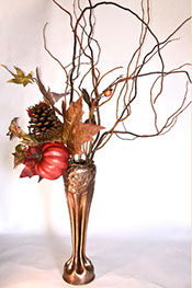 Shell with eight long flutes and a bulbous top embossed with daisies. Bouquet of fall dry flowers.