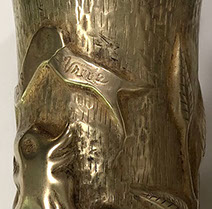 Shell with a long ribbon with Orlog [war] 1914-15-16-17-1918 Vrede [peace]. Leafy branch on a dashed background.