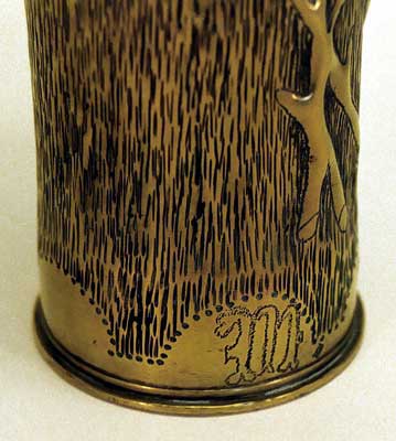 Shell with roses, prickly stems, leaves, engraved M and P at the base with scalloped pattern.