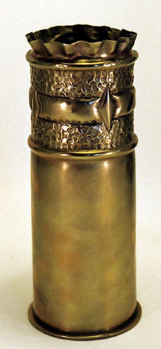 Shell with a pie top crust, two circular bands&nbsp; decorated by a larger band&nbsp; and diamond shapes on embossed back. Lower part un-worked.