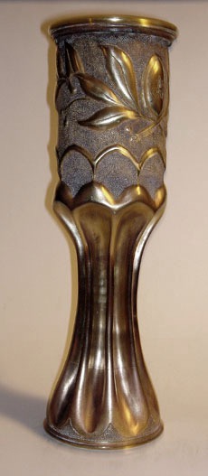 Fluted shell with a garland of palm and oak leaves on a stippled background.